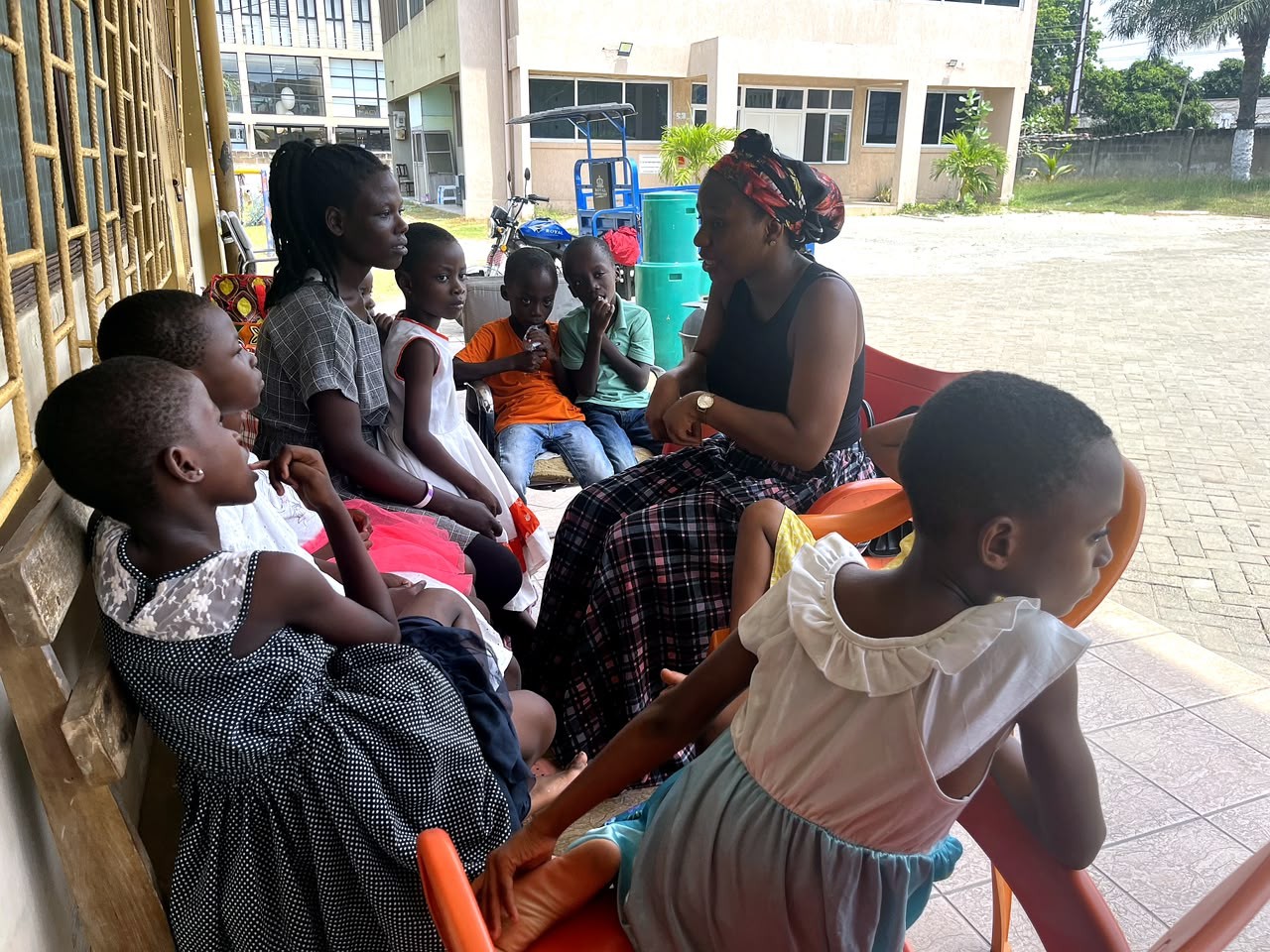 A Nuvanta volunteer sitting with a group of children during a community outreach visit
